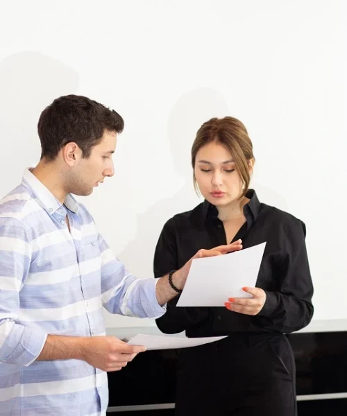 front-view-young-attractive-businesswoman-black-shirt-along-with-young-man-discussing-graphics-desk-